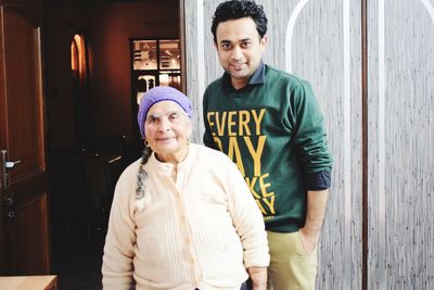 Portrait of grandmother and grandson standing at home