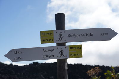 Low angle view of information sign against sky