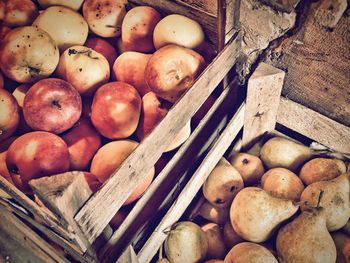 High angle view of apples and pears in crate at market