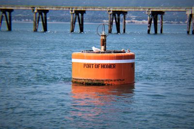 Close-up of text on pier over sea against sky