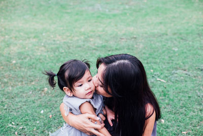 Happy mother and daughter on grass