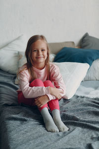 Portrait of cute girl lying on bed at home