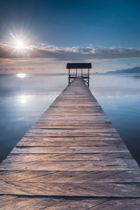 Pier over sea against sky during sunset