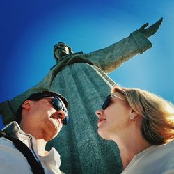 Portrait of young man wearing sunglasses against clear blue sky