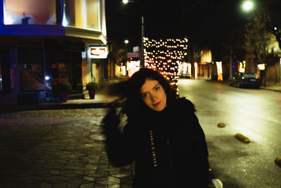 Portrait of young woman standing in city