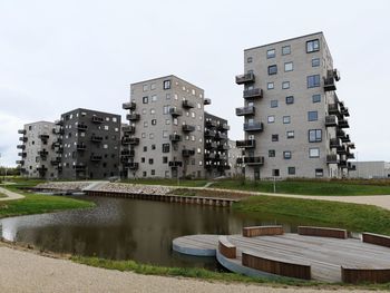 Canal amidst buildings against sky in city