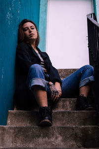 Portrait of young woman sitting on staircase