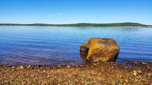 Scenic view of lake against clear blue sky