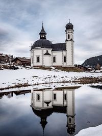 Reflection of building on water against sky