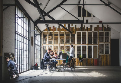 Businessmen and businesswomen brainstorming in board room during meeting at creative workplace