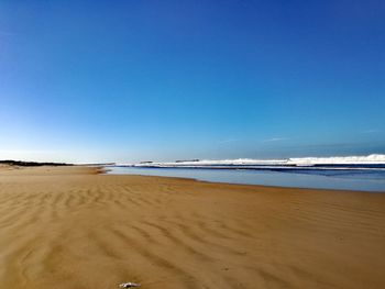 View of beach against clear blue sky