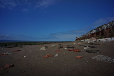 Scenic view of beach against blue sky