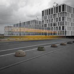 View of office building against cloudy sky