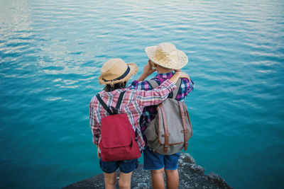 Friends standing at lakeshore