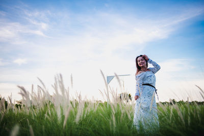 Woman standing on field against sky