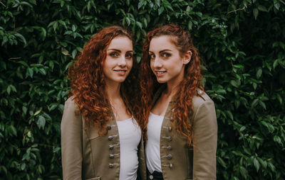 Portrait of smiling women standing against plants