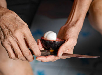 Cropped hands of man cutting fruit