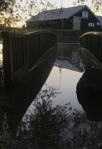 Reflection of bridge on water in lake against sky