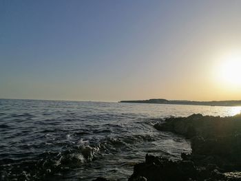 Scenic view of sea against clear sky during sunset