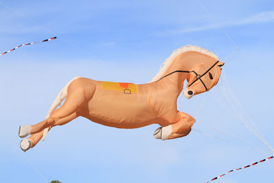 Low angle view of horse shape kite flying in sky