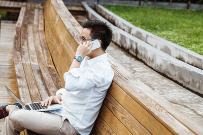 Side view of senior man sitting on wood