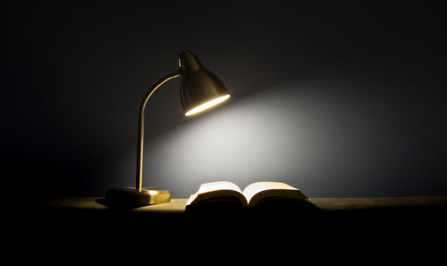 Open book on illuminated lamp