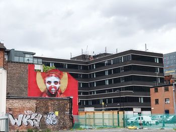 Portrait of historic building by city against sky