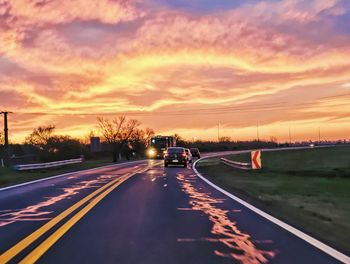 Empty road against sky during sunset