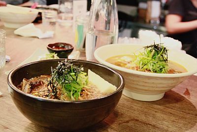 Close-up of ramen noodles served in soup bowls on table