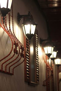 Low angle view of illuminated lighting equipment hanging in ceiling