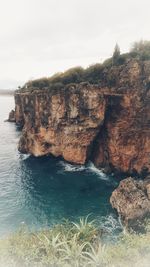 Rock formations in sea against sky