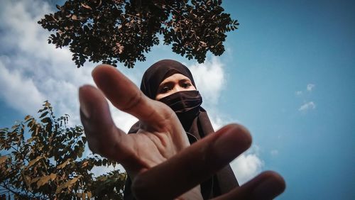 Low angle portrait of man against sky