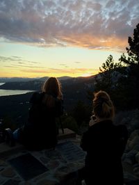 Man sitting on rock at sunset