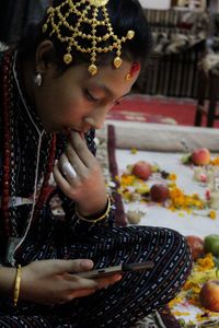 Close-up of girl in traditional dress looking at mobile phone