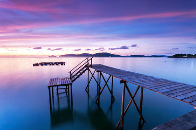 Pier over sea against sky during sunset