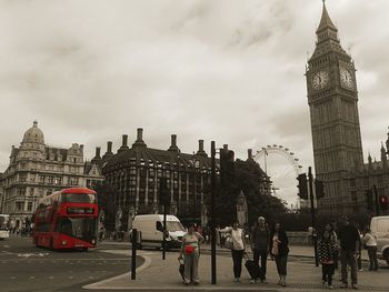 People in city against cloudy sky