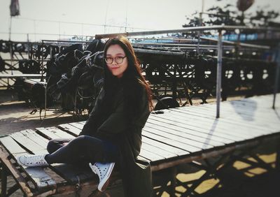 Portrait of smiling young woman sitting outdoors