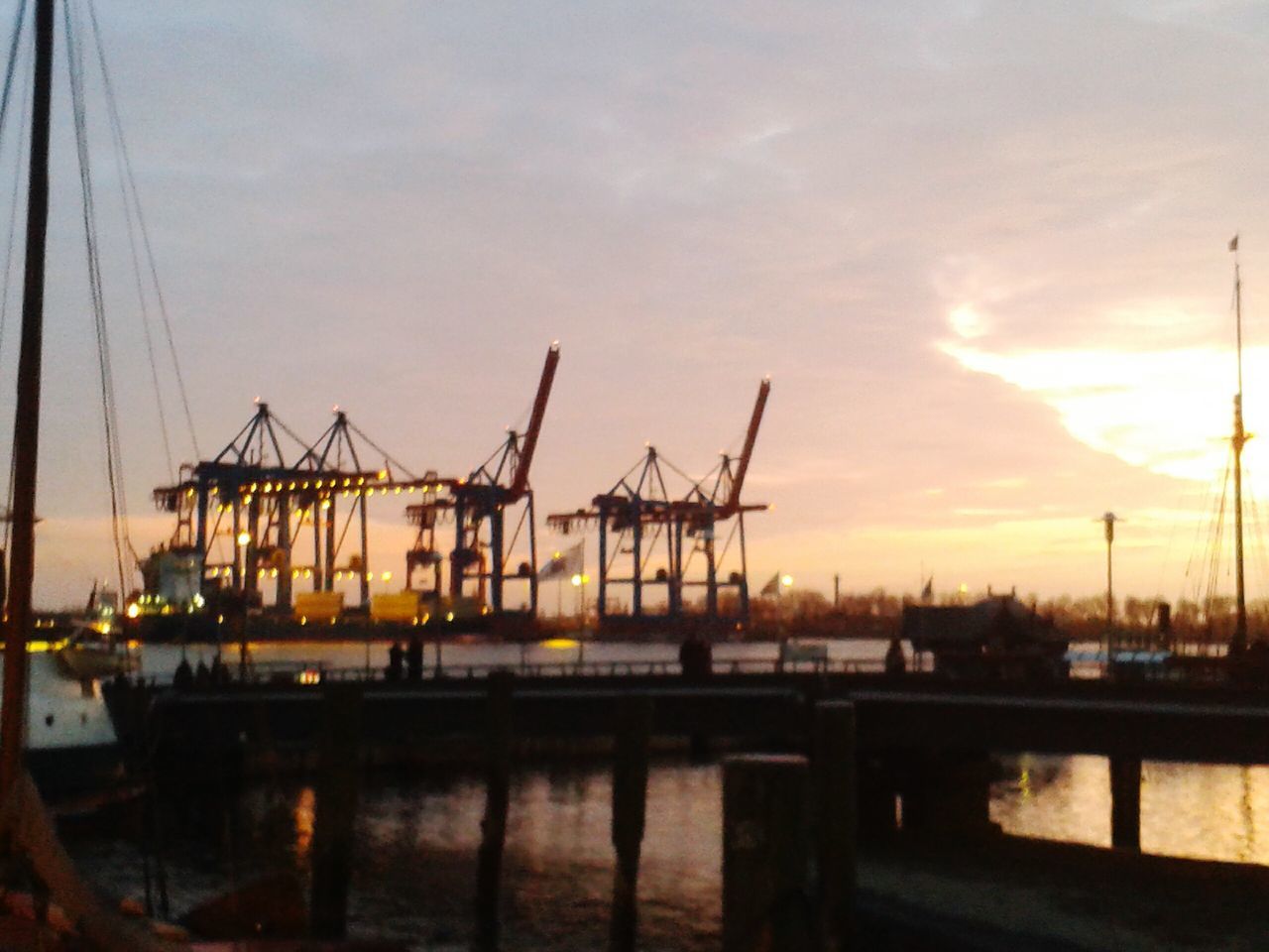 sunset, crane - construction machinery, transportation, nautical vessel, water, harbor, commercial dock, mode of transport, sky, crane, orange color, industry, waterfront, moored, boat, freight transportation, built structure, development, architecture, mast