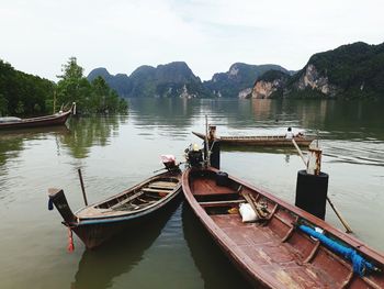 Boats moored in lake against sky