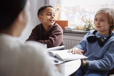 Two boys doing homework at dining table