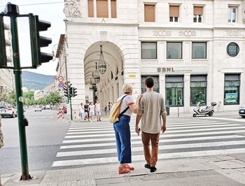 Rear view of people walking on road