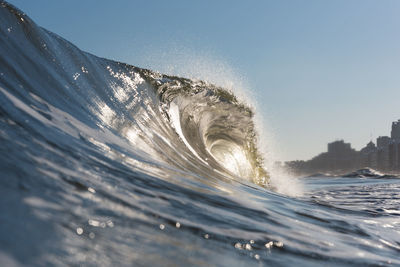 Close-up of sea waves splashing against clear sky