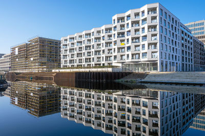 Modern buildings in city against clear blue sky