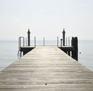 Wooden pier on sea against sky