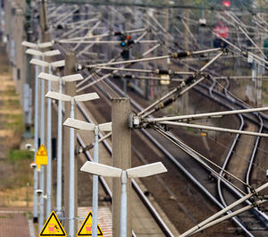 Row of electric lanterns next to pantographs on a platform next to the rails of the railway