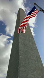 Low angle view of american flag against cloudy sky