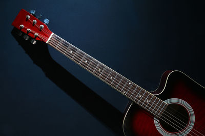 Close-up of acoustic guitar against black background