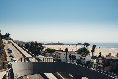 High angle view of buildings by sea against clear sky