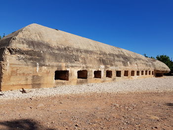 Old ruin on field against clear blue sky