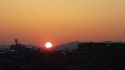 Silhouette cityscape against clear sky during sunset